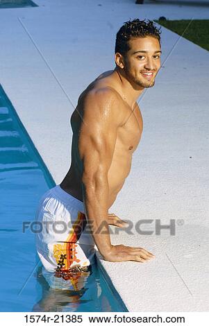 Portrait of a young man getting out of a swimming pool View Large Photo Image Stock Photography - Portrait of a young man getting out of a swimming pool. Fotosearch