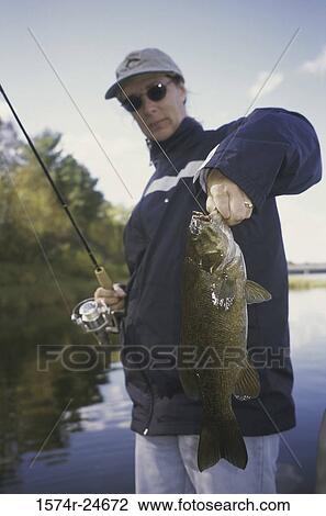 Portrait of a young woman holding a fish View Large Photo Image Stock Image - Portrait of a young woman holding a fish. Fotosearch