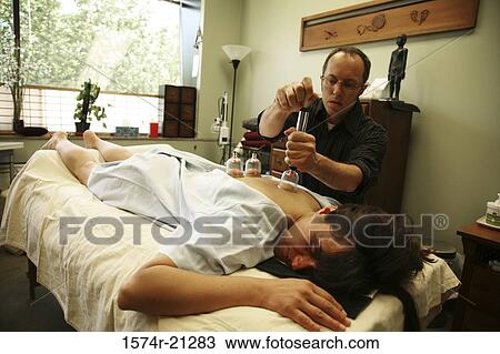 Stock Image - Rear view of a mature woman getting Ba Guan therapy. Fotosearch