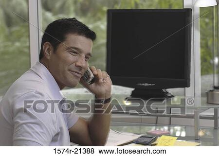 Stock Photo - Side profile of a businessman talking on a mobile phone. Fotosearch