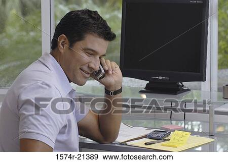 Stock Photo - Side profile of a businessman talking on a mobile phone. Fotosearch