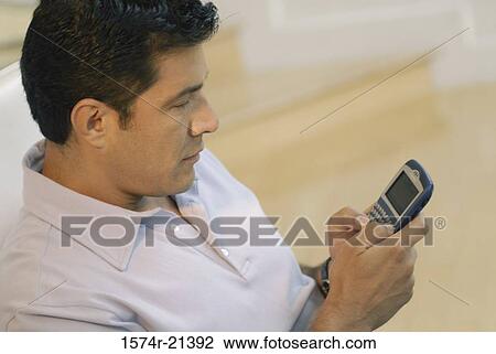 Side profile of a businessman using a personal data assistant View Large Photo Image Stock Image - Side profile of a businessman using a personal data assistant. Fotosearch