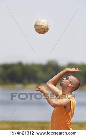 Side profile of a mid adult man playing volleyball on the beach View Large Photo Image Stock Image - Side profile of a mid adult man playing volleyball on the beach. Fotosearch