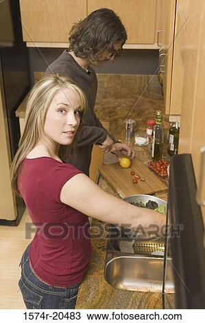 Side profile of a young couple cooking in the kitchen View Large Photo Image Stock Image - Side profile of a young couple cooking in the kitchen. Fotosearch