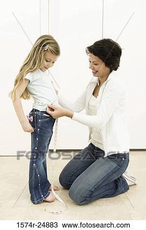 Side profile of a young woman measuring the waist of her daughter with a tape measure View Large Photo Image Stock Image - Side profile of a young woman measuring the waist of her daughter with a tape measure. Fotosearch
