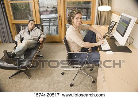 Side profile of a young woman using a computer and a young man sleeping on a chaise longue View Large Photo Image Stock Photo - Side profile of a young woman using a computer and a young man sleeping on a chaise longue. Fotosearch