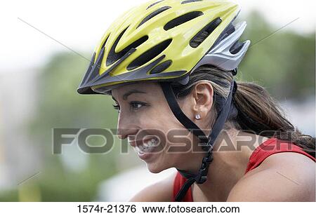 Side profile of a young woman wearing a cycling helmet View Large Photo Image Stock Photograph - Side profile of a young woman wearing a cycling helmet. Fotosearch