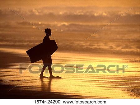 Silhouette of a man carrying a boogie board on the beach View Large Photo Image Stock Image - Silhouette of a man carrying a boogie board on the beach. Fotosearch