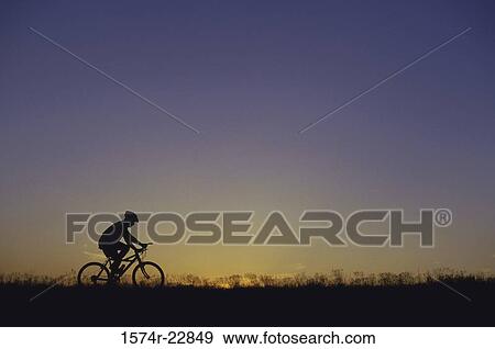 Silhouette of a man sitting on a bicycle View Large Photo Image Stock Photo - Silhouette of a man sitting on a bicycle. Fotosearch