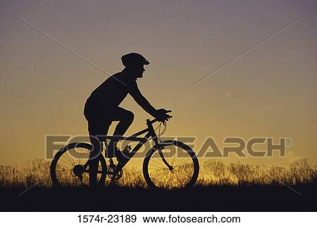 Silhouette of a man sitting on a bicycle View Large Photo Image Stock Photo - Silhouette of a man sitting on a bicycle. Fotosearch