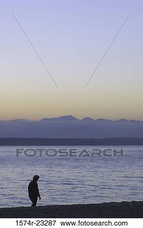Silhouette of a person walking on the beach View Large Photo Image Stock Photo - Silhouette of a person walking on the beach. Fotosearch