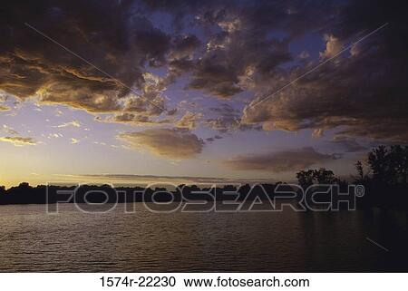 Silhouette of trees across a lake during sunset, Kansas, USA View Large Photo Image Stock Image - Silhouette of trees across a lake during sunset, Kansas, USA. Fotosearch