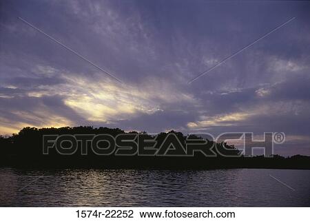 Stock Image - Sunset over a lake. Fotosearch