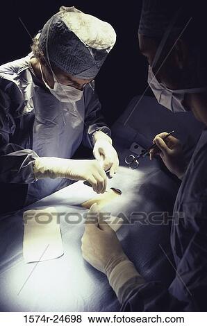 Surgeons operating in an operating room View Large Photo Image Stock Photo - Surgeons operating in an operating room. Fotosearch