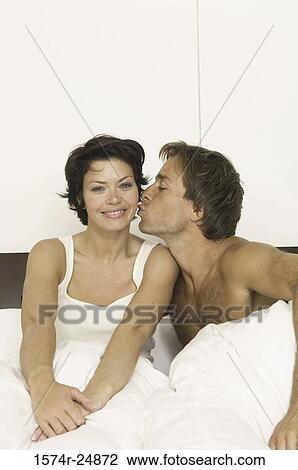 Young man kissing a young woman's cheek View Large Photo Image Stock Image - Young man kissing a young woman's cheek. Fotosearch