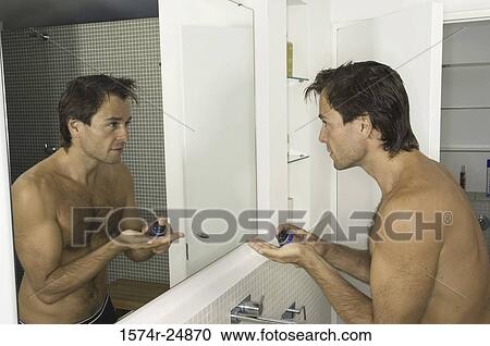 Young man pouring shaving cream on his palm View Large Photo Image Stock Image - Young man pouring shaving cream on his palm. Fotosearch