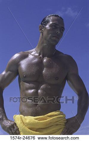 Stock Photograph - Young man standing with arms akimbo. Fotosearch