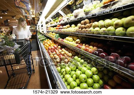 Young woman buying fruit in a supermarket View Large Photo Image Stock Photo - Young woman buying fruit in a supermarket. Fotosearch