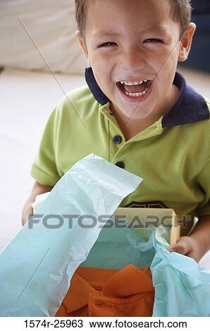 Boy holding a gift and laughing View Large Photo Image Stock Image - Boy holding a gift and laughing. Fotosearch