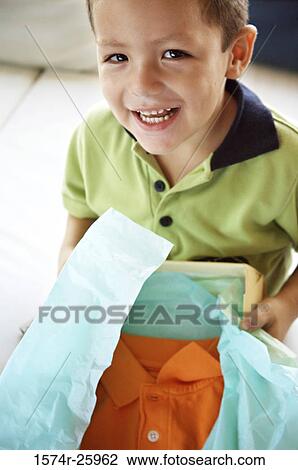 Boy holding a gift and smiling View Large Photo Image Stock Image - Boy holding a gift and smiling. Fotosearch