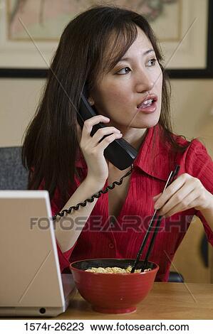 Businesswoman talking on the phone and eating View Large Photo Image Stock Image - Businesswoman talking on the phone and eating. Fotosearch