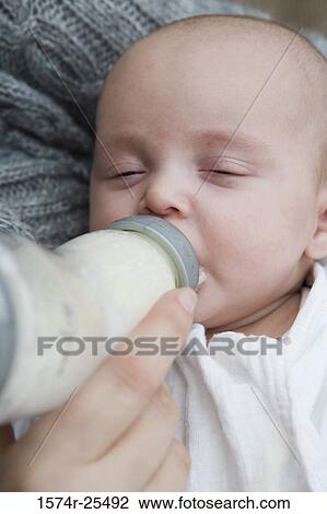 Close-up of a baby drinking a bottle View Large Photo Image Stock Image - Close-up of a baby drinking a bottle. Fotosearch