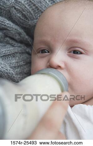 Stock Image - Close-up of a baby drinking a bottle. Fotosearch