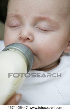 Stock Photo - Close-up of a baby drinking from a baby bottle. Fotosearch