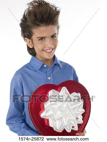 Close-up of a boy holding a heart shape valentine and smiling View Large Photo Image Stock Image - Close-up of a boy holding a heart shape valentine and smiling. Fotosearch