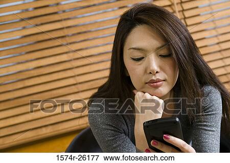 Stock Photo - Close-up of a businesswoman holding a personal data assistant. Fotosearch
