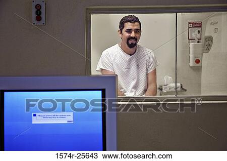 Stock Image - Close-up of a computer monitor with a patient smiling in the background. Fotosearch