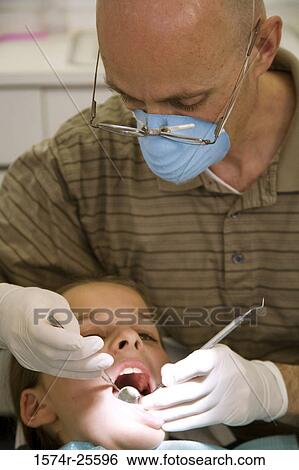 Close-up of a dentist examining a boy View Large Photo Image Stock Photograph - Close-up of a dentist examining a boy. Fotosearch