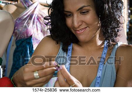 Close-up of a female fashion designer smiling in a clothing store View Large Photo Image Stock Photograph - Close-up of a female fashion designer smiling in a clothing store. Fotosearch
