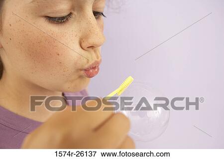 Close-up of a girl blowing a bubble with a bubble wand View Large Photo Image Stock Photo - Close-up of a girl blowing a bubble with a bubble wand. Fotosearch