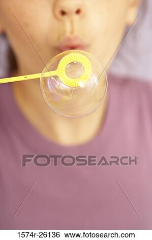 Close-up of a girl blowing a bubble with a bubble wand View Large Photo Image Stock Photograph - Close-up of a girl blowing a bubble with a bubble wand. Fotosearch