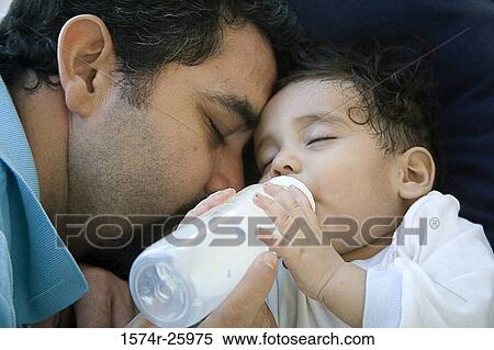 Close-up of a mature man feeding his baby with a bottle View Large Photo Image Stock Photography - Close-up of a mature man feeding his baby with a bottle. Fotosearch