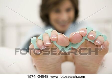Close-up of a mature woman's feet with toe dividers View Large Photo Image Stock Photo - Close-up of a mature woman's feet with toe dividers. Fotosearch