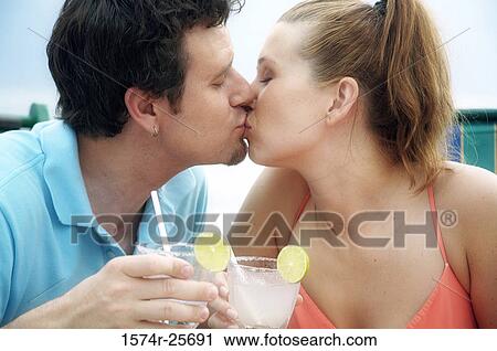 Close-up of a mid adult man and a young woman kissing each other View Large Photo Image Stock Image - Close-up of a mid adult man and a young woman kissing each other. Fotosearch