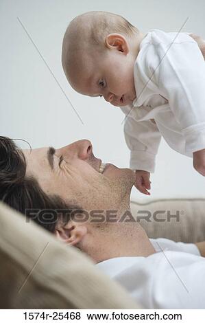 Stock Photo - Close-up of a mid adult man holding his baby. Fotosearch