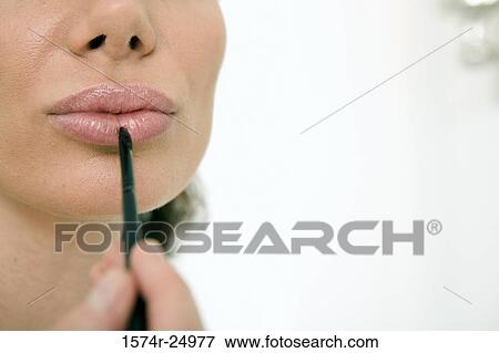 Close-up of a mid adult woman applying lipstick to her lips with a make-up brush View Large Photo Image Stock Photo - Close-up of a mid adult woman applying lipstick to her lips with a make-up brush. Fotosearch