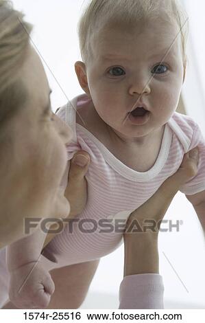 Close-up of a mid adult woman holding her daughter View Large Photo Image Stock Photograph - Close-up of a mid adult woman holding her daughter. Fotosearch