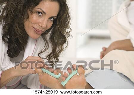Close-up of a mid adult woman painting the toenails of a mature man View Large Photo Image Stock Photo - Close-up of a mid adult woman painting the toenails of a mature man. Fotosearch