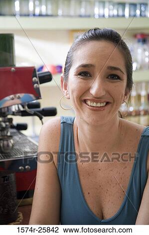 Stock Image - Close-up of a mid adult woman smiling in a cafe. Fotosearch