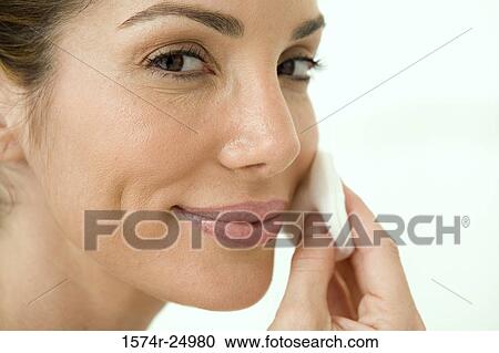 Close-up of a mid adult woman wiping her face with a cotton pad View Large Photo Image Stock Image - Close-up of a mid adult woman wiping her face with a cotton pad. Fotosearch