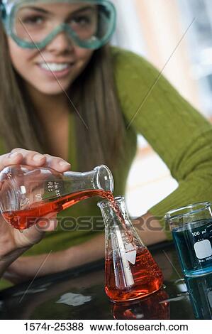 Stock Photo - Close-up of a student pouring liquid in a beaker in a science lab. Fotosearch