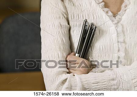 Stock Photo - Close-up of a woman holding pens. Fotosearch