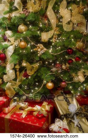 Stock Image - Close-up of Christmas presents in front of a Christmas tree. Fotosearch