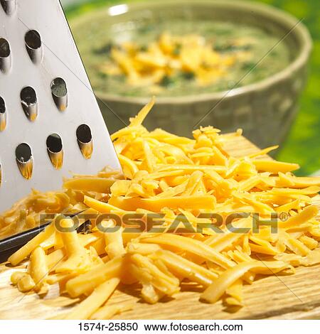 Close-up of grated cheese with a cheese grater on a cutting board View Large Photo Image Stock Image - Close-up of grated cheese with a cheese grater on a cutting board. Fotosearch