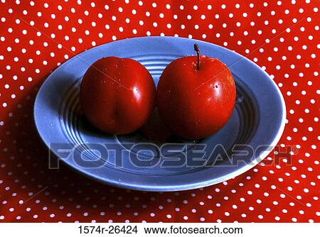 Picture - Close-up of two plums on a plate. Fotosearch