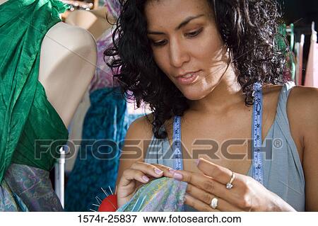 Female fashion designer working on a dress on a mannequin View Large Photo Image Stock Photo - Female fashion designer working on a dress on a mannequin. Fotosearch